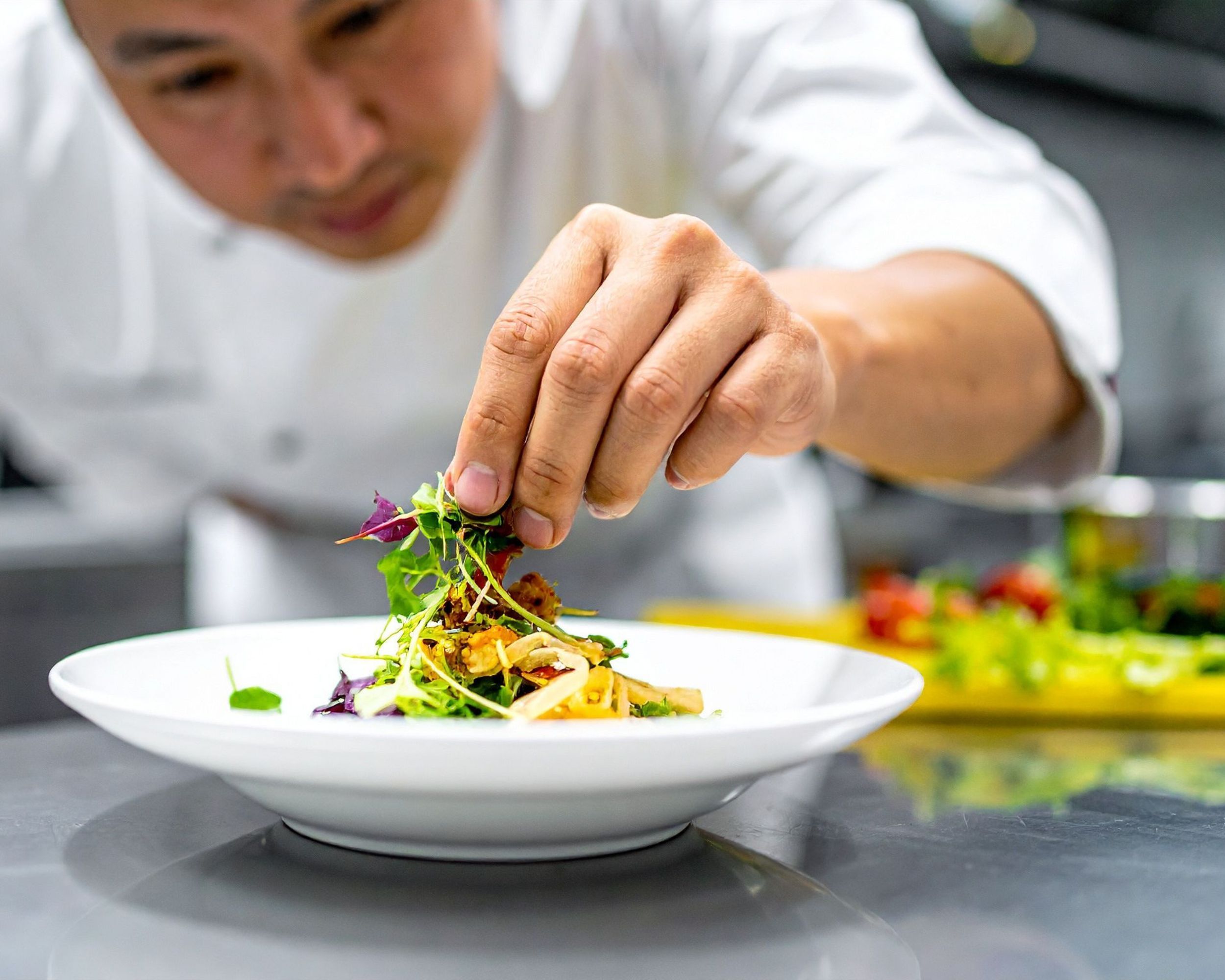Chef finishing a plate with fresh microgreens